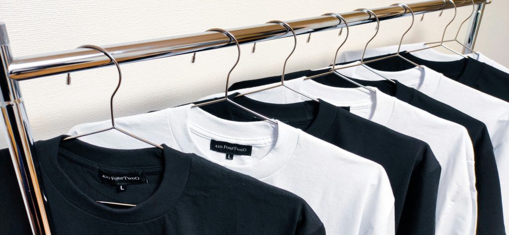 black crew neck shirt on white plastic clothes hanger